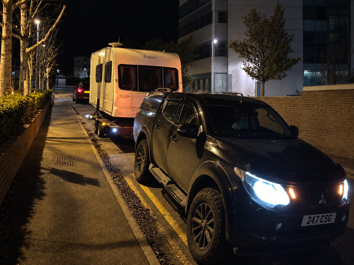 CSG pickup transporting a caravan on a trailer at night