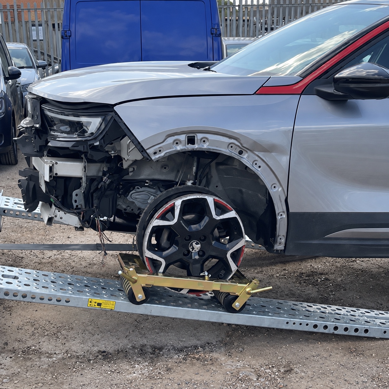 Damaged car with its front wheel supported by a wheel skate on a recovery ramp