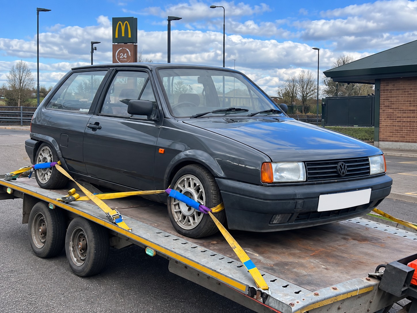 Grey Volkswagen Golf secured to a trailer with transport straps