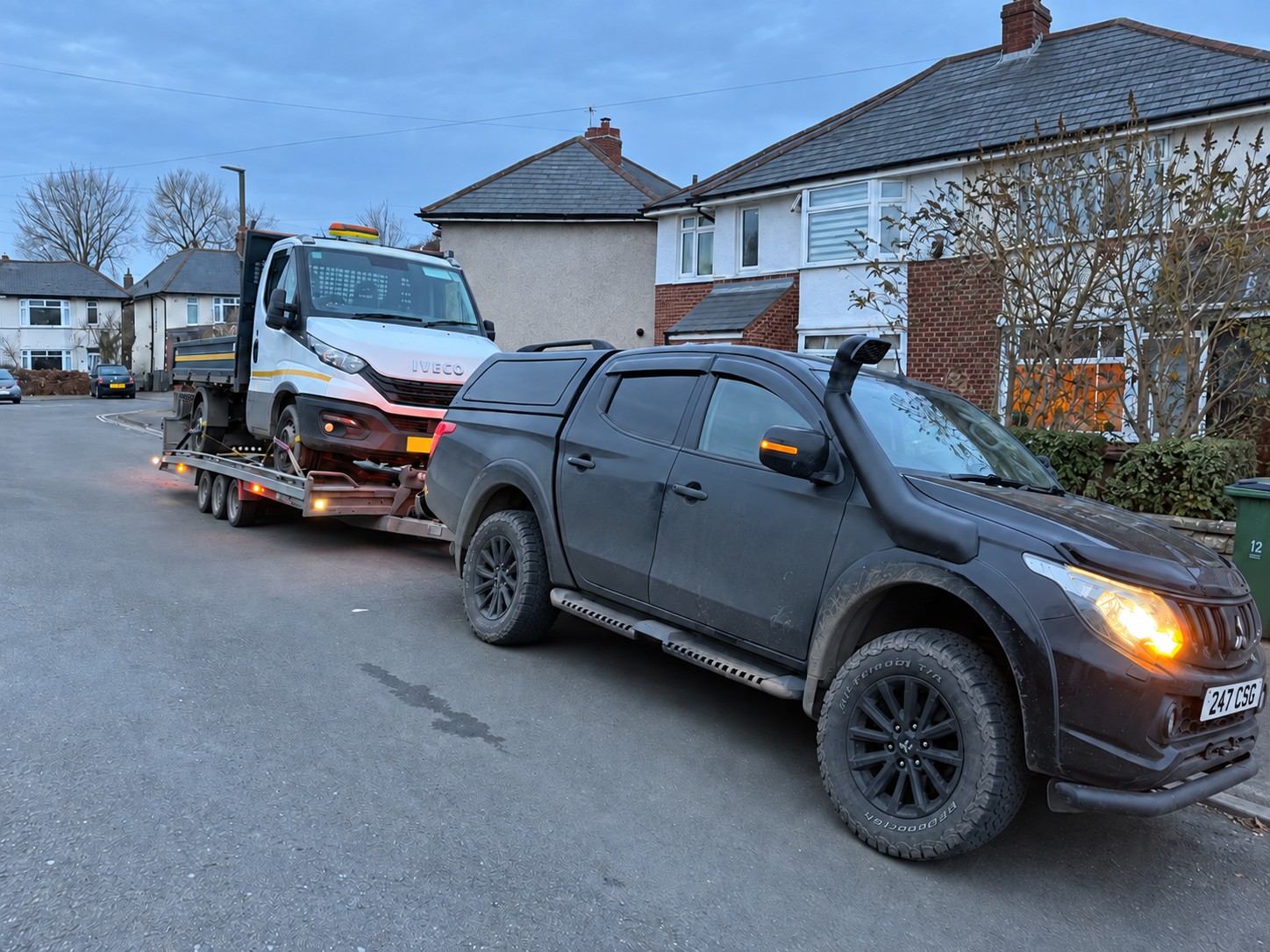 CSG pickup transporting a white Iveco truck on a trailer