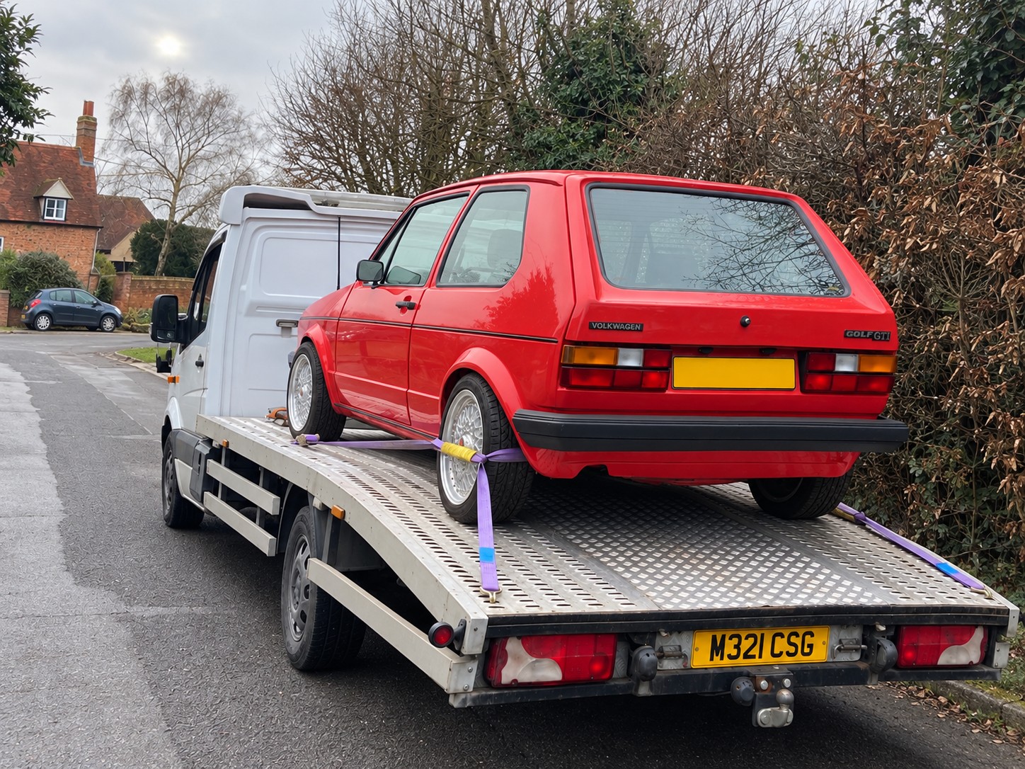 Red classic Volkswagen Golf secured on a CSG recovery truck